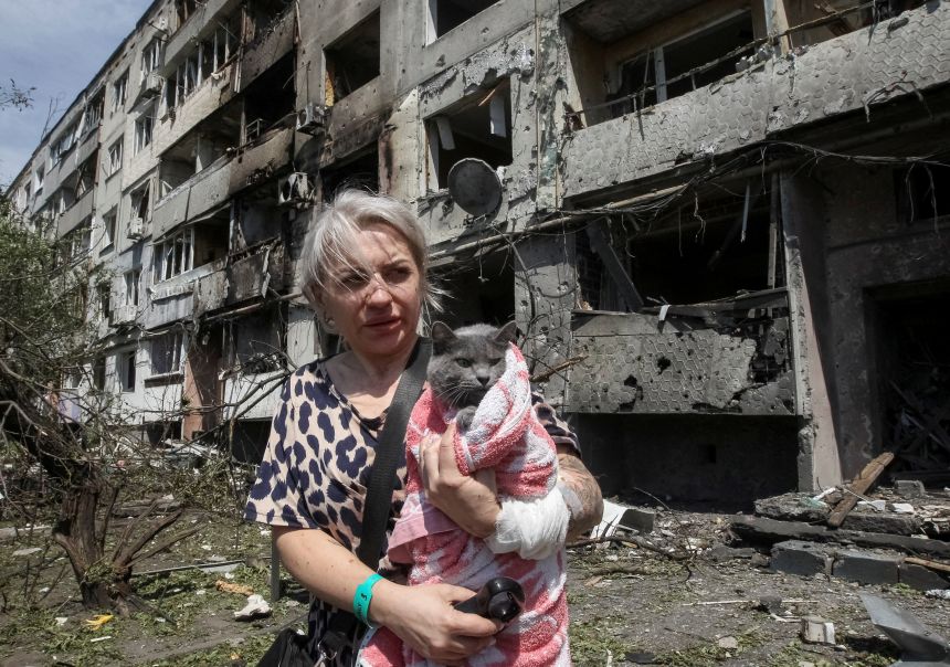 A woman with her cat stands near an apartment building hit by a Russian airstrike in the town of Pavlohrad in eastern Ukraine on July 20.