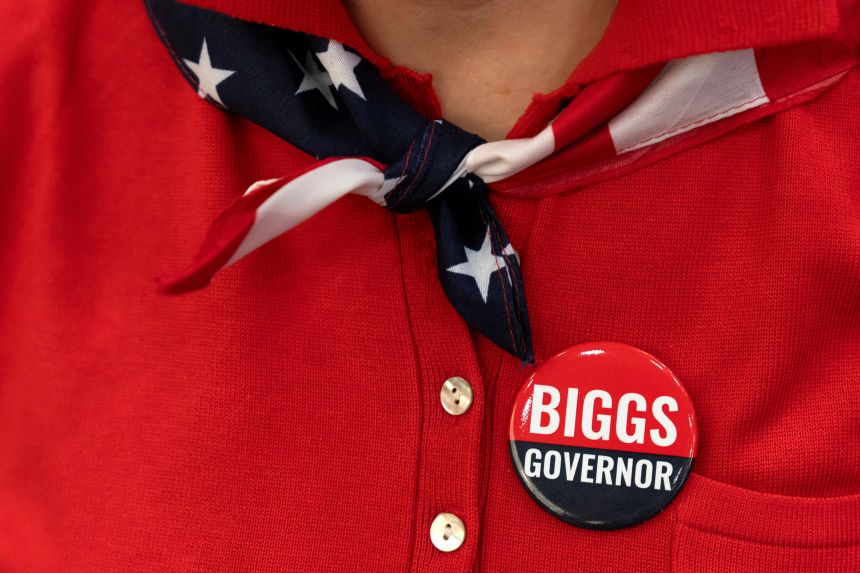 A woman sports a campaign button that reads “Biggs Governor” during a rally in support Rep. Andy Biggs in Gilbert, Arizona, July 17.