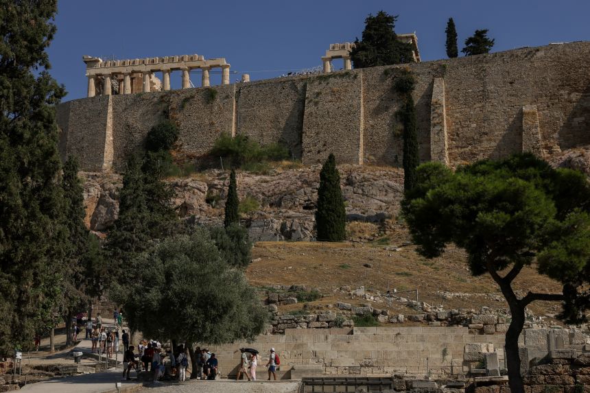 Tourists walk inside the Acropolis archaeological site near to where two tourists were stabbed in Athens, Greece on Tuesday morning.