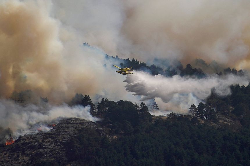 A firefighting plane pictured releasing water over the La Mierla fire in Guadalajara, Spain, on Wednesday.