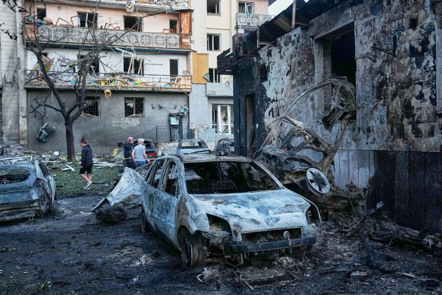 Local residents wander among debris Sunday following a Russian missile attack in Kyiv, Ukraine.
