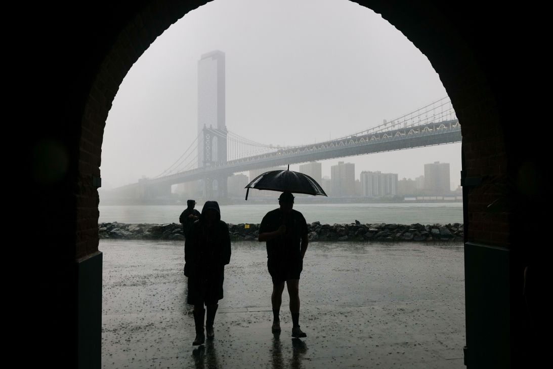 People walk through the rain in the Dumbo neighborhood in Brooklyn as severe storms moved through the New York area on July 21, 2026 in New York City.