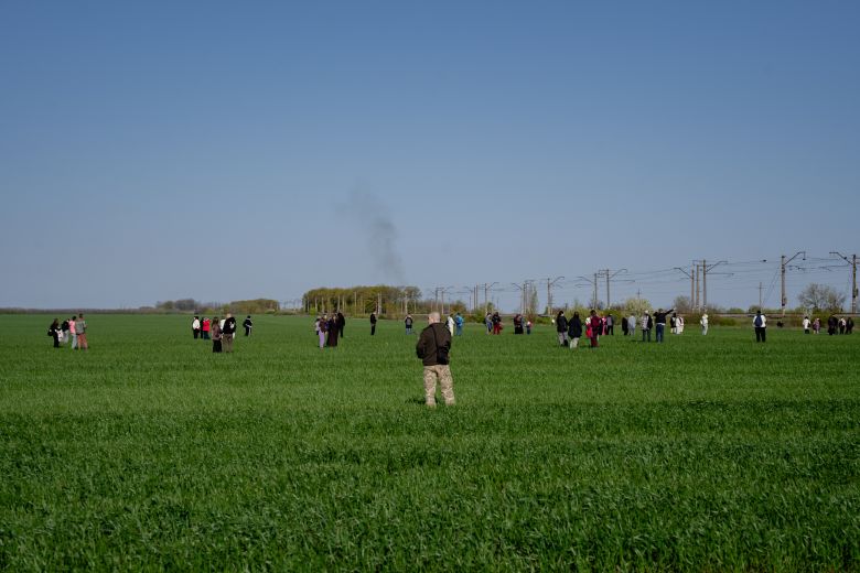 gettyimages-2274654294 Passengers from a Lviv–Dnipro train move away from the train into a field due to the threat of a Russian drone attack on May 3, 2026, as smoke from a drone interception rises in Dnipropetrovsk region.