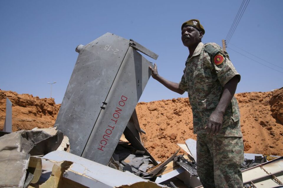 A man stands in a hole filled with drone components on March 29, 2026, in El-Obeid, Sudan.