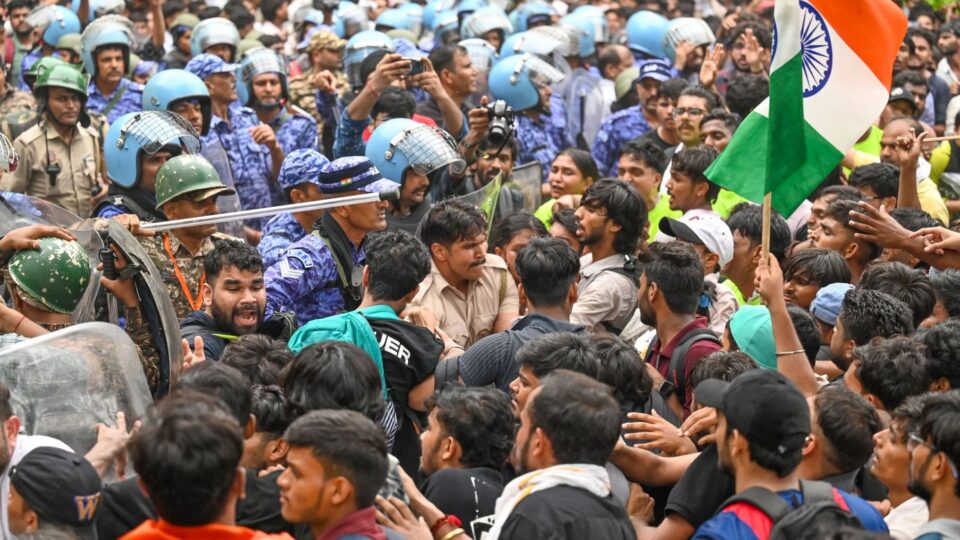 Security personnel use batons to disperse protesters during a march towards Parliament on July 20, 2026 in New Delhi, India.
