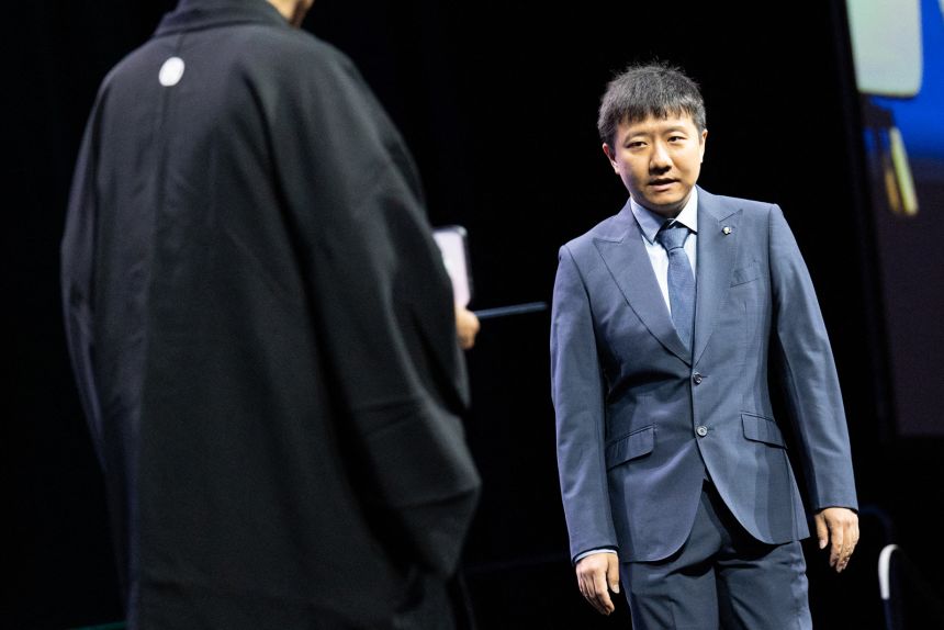 gettyimages-2286690913 Mathematician Deng Yu walks onstage as he is awarded the 2026 Fields Medal during the International Congress of Mathematicians in Philadelphia on Thursday.